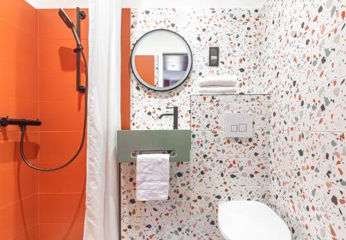 uma casa de banho com um WC e um espelho. em Seakub hotel em Royan