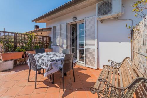 a patio with a table and chairs and a bench at La Palazzina nel Verde - Goelba in Campo nell'Elba