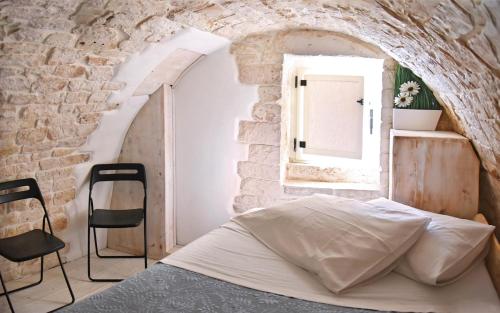 1 dormitorio con 1 cama en una pared de piedra en l'angolo di Gaudì, alcoba Fascinosa, en Putignano