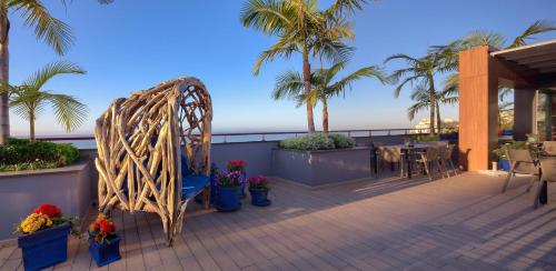 a balcony with a table and chairs and palm trees at The Views Monumental in Funchal