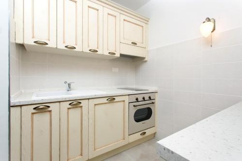 a kitchen with white cabinets and a sink at Split Inn Apartments in Split