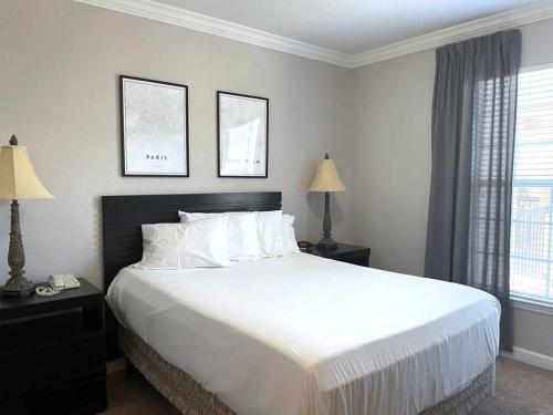 - une chambre avec un grand lit blanc et deux lampes dans l'établissement Tuscana Gem! 2 bed 2 bath condo near Disney & Golf, à Kissimmee