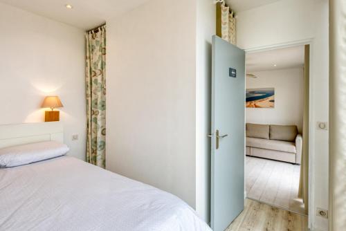 a bedroom with a bed and a couch in a room at La Rose des Sables Arcachon in Arcachon