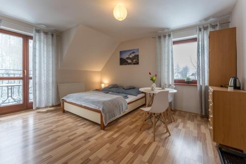 - une chambre avec un lit, une table et des fenêtres dans l'établissement Willa Limba, à Krościenko nad Dunajcem