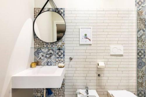 W białej łazience znajduje się umywalka i lustro. w obiekcie Sunny Beach Bari w mieście Bari