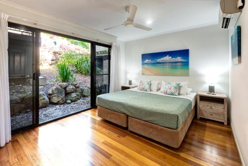 a bedroom with a bed and a large window at The Panorama 3, Hamilton Island 2 Bedroom 2 Bathroom Ocean View Modern Apartment in Hamilton Island