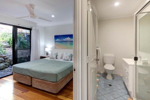 ein Schlafzimmer mit einem Bett und ein Badezimmer mit einer Dusche in der Unterkunft The Panorama 3, Hamilton Island 2 Bedroom 2 Bathroom Ocean View Modern Apartment in Hamilton Island
