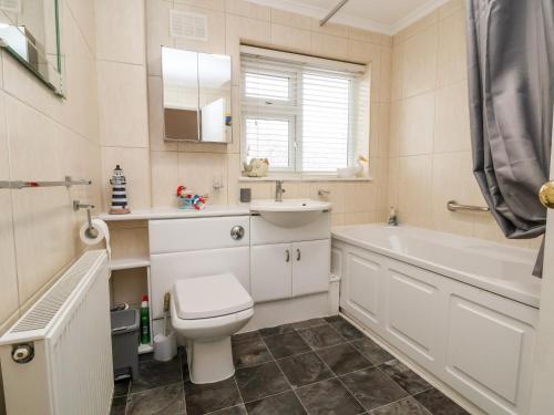 a bathroom with a toilet and a tub and a sink at 17 Third Avenue in Prestatyn