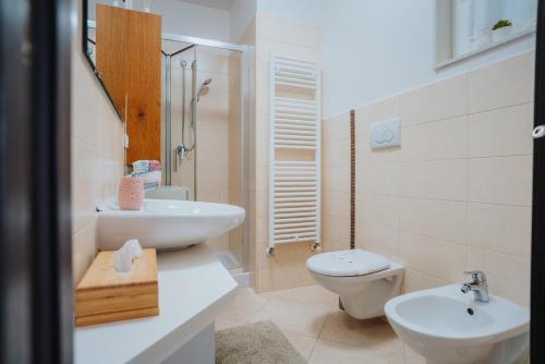 a white bathroom with a sink and a toilet at Dimora Donna Matilde in Polignano a Mare