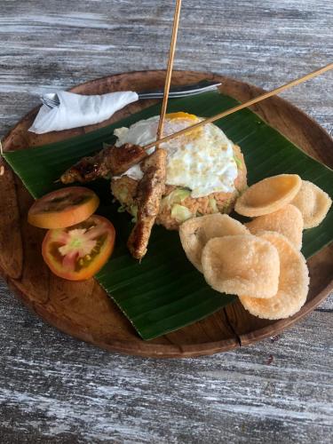 a plate of food with eggs and other foods on a banana leaf at Makawi Tuwa in Seraya
