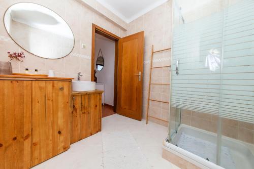 Un baño con ducha, lavabo y espejo. en Westway Rossio Holiday Place, en Luz