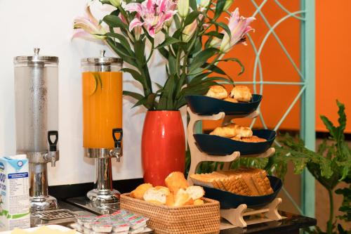 a table with bowls of bread and a vase with flowers at Hoi An Ivy Hotel in Hoi An