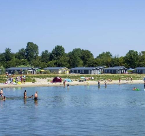 a group of people in the water at a beach at BJ Chalets - De Rug 3 - Vakantiepark Lauwersoog - Luxe chalet MET vaatwasser en inloopkast! Vroege incheck! MET AIRCO! in Lauwersoog