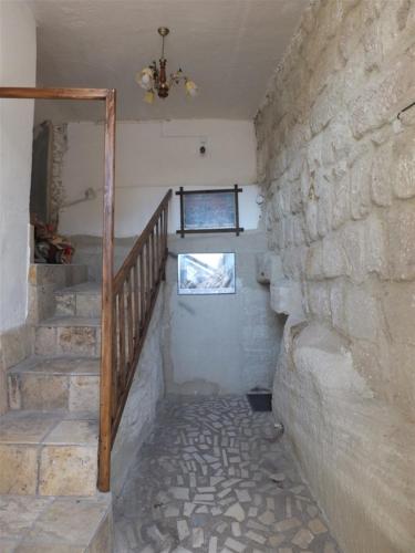 a staircase in a room with a stone wall at Anatolia cave hotel Pension in Goreme