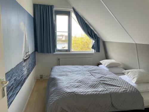 een slaapkamer met een groot bed en een raam bij Klipper in Terherne