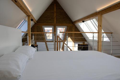 a white bed in a room with windows at Apartment im alten Fronhof in Balingen