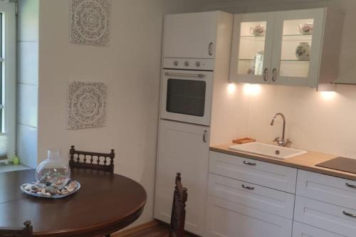 a small kitchen with a table and a sink at Ferienwohnung Altneukoog in Tetenbüll