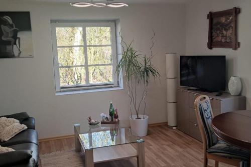 a living room with a table and a tv at Ferienwohnung Altneukoog in Tetenbüll