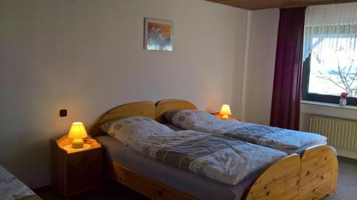 2 Betten in einem Zimmer mit zwei Lampen in der Unterkunft Ferienwohnung "Anja" in Fladungen