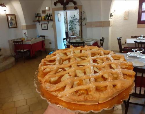 una persona che tiene una grande torta di mele su un tavolo di Pier Delle Vigne B&B a Pineto