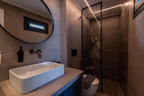 uma casa de banho com um lavatório, um espelho e um WC. em Il Terrazzo in Heraklion em Heraclião