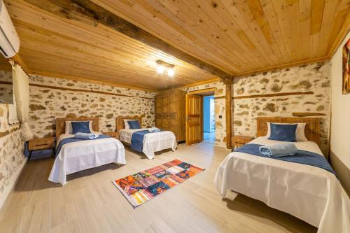 a room with two beds and a wooden ceiling at Villa Nostalji Kalkan Bezirganda Havuzlu Villa in Bezirgân