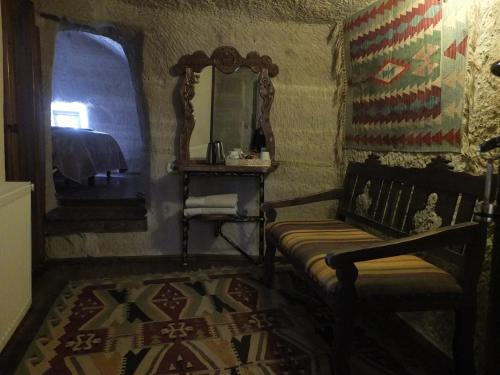 a room with a chair and a mirror and a rug at Anatolia cave hotel Pension in Goreme
