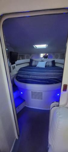 a small room with a bed with blue lights at Billionaire Yach Resort - Muelle Marina Puerto Cancun in Cancún