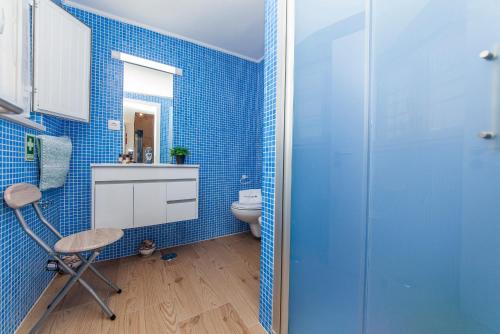 uma casa de banho azul com um WC e uma cadeira em B54 - Casa Azul in Burgau em Budens