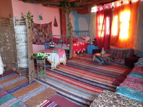 a living room with two beds and a rug at Rural Guest House فندق البيت الريفي in Tanta