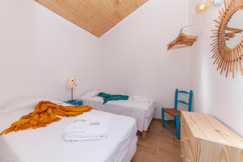 a room with two beds and a table and a mirror at B54 - Casa Azul in Burgau in Budens