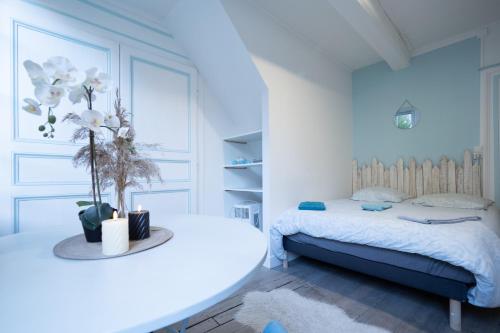 a bedroom with a bed and a table with flowers on it at L'Oiseau De La Cathédrale - Calme - Jardin - Wifi in Troyes