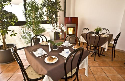 a dining room with tables and chairs and a fireplace at Villa Santacroce in San Giovanni Rotondo