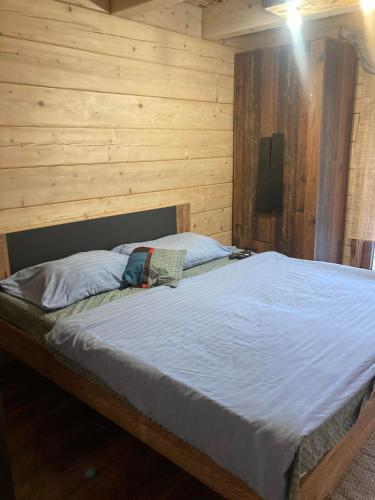a bed in a room with a wooden wall at Chata Peťo in Bžany
