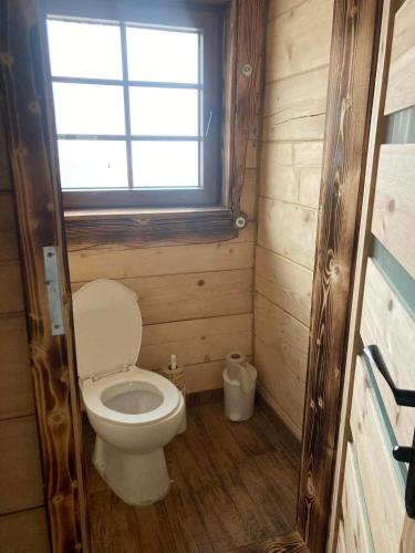 a small bathroom with a toilet and a window at Chata Peťo in Bžany