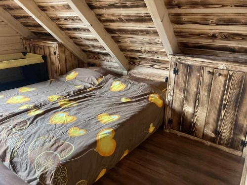 a bedroom with a bed in a wooden cabin at Chata Peťo in Bžany