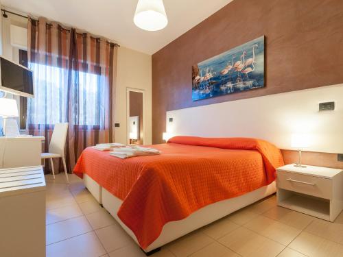 a bedroom with a large bed with an orange blanket at Al Molì Affittacamere in Cagliari