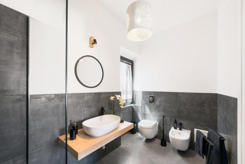 a bathroom with two toilets and a sink and a mirror at La maison del corso in Santa Teresa Gallura