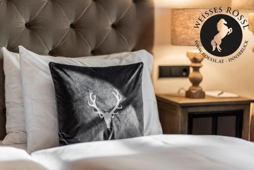 a bed with a pillow with a deer on it at Boutiquehotel Weisses Rössl in Innsbruck
