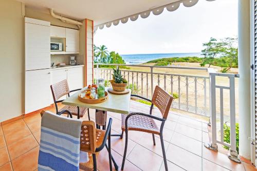 a balcony with a table and chairs and the ocean at Village Pierre & Vacances Sainte Anne in Sainte-Anne