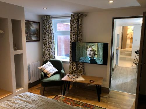 a living room with a flat screen tv on a wall at cosy quiet apartment in Nottingham
