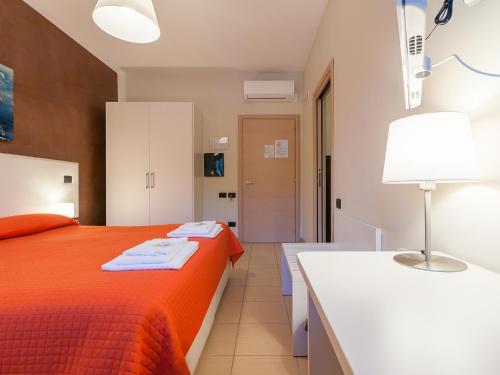 a bedroom with a orange bed and a white desk at Al Molì Affittacamere in Cagliari
