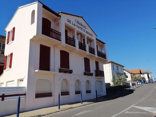 un bâtiment blanc au bord d'une rue dans l'établissement Appartement a 70m de la plage et l estacade de Capbreton, à Capbreton