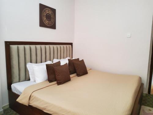 a bedroom with a bed with brown and white pillows at Royal Apartments in Nuwara Eliya