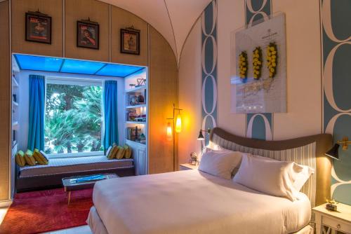 um quarto com uma cama grande e uma janela em Capri Tiberio Palace - The Leading Hotels of the World em Capri