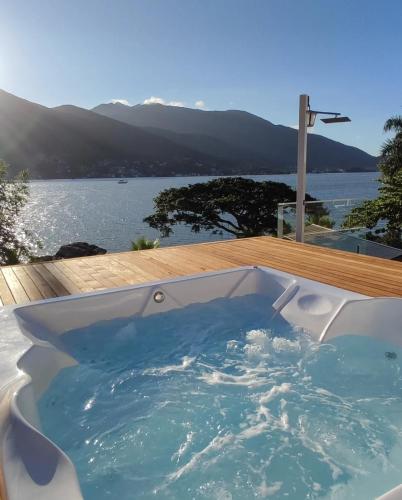 a jacuzzi tub with a view of the water at Paraíso da Enseada de Brito in Palhoça