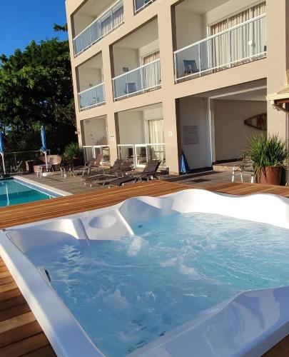 a hot tub on a deck next to a building at Paraíso da Enseada de Brito in Palhoça