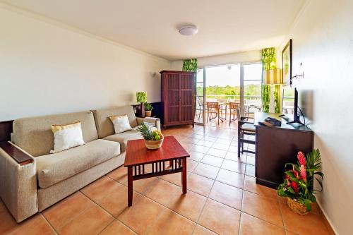 a living room with a couch and a table at Village Pierre & Vacances Sainte Anne in Sainte-Anne