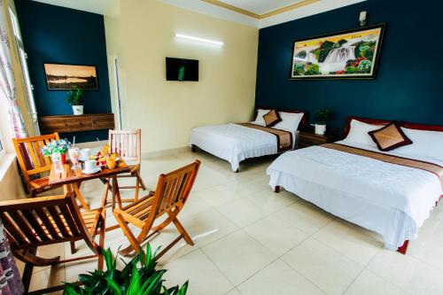 1 dormitorio con 2 camas, mesa y sillas en Thanh Phat Phong Nha, en Phong Nha