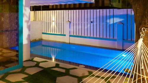 a hammock in front of a swimming pool at Cozy Nook- Artsy 3BHK with Private Pool- Lonavala By StayMonkey in Lonavala